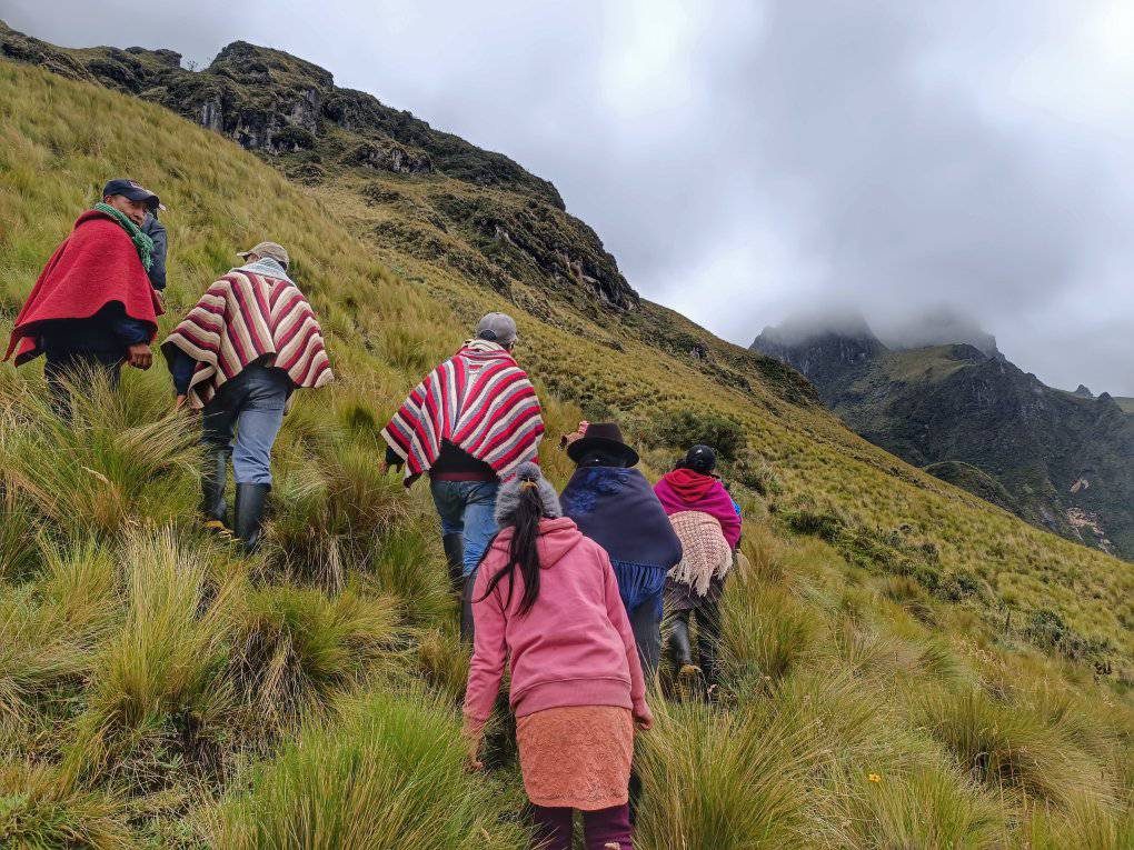 Un gruppo di persone in poncho colorati cammina su un sentiero di montagna
